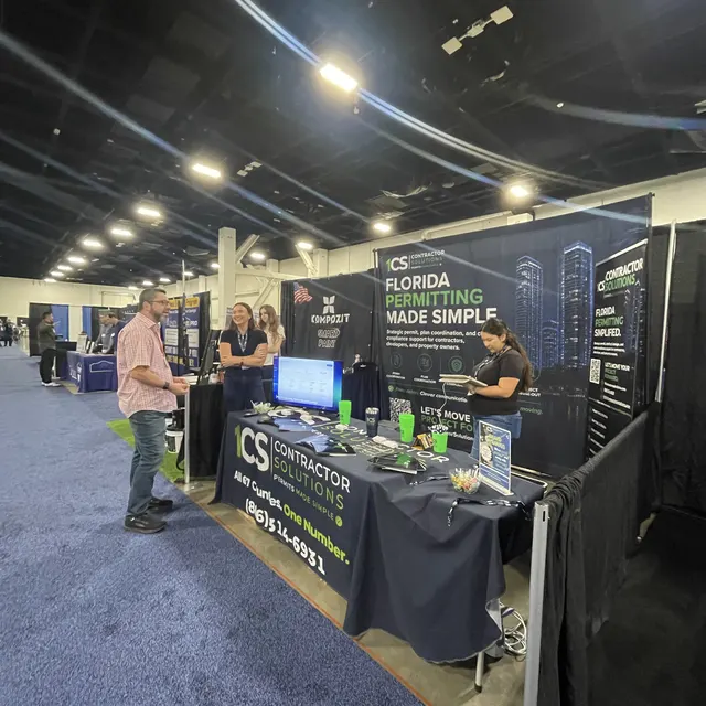 A visitor talks with the 1CS team at our booth in the exhibit hall